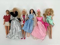 All six dolls laid side by side displaying full outfits