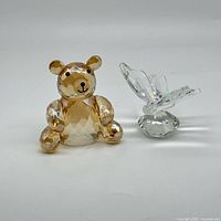 Amber crystal bear and clear butterfly paperweights side-by-side