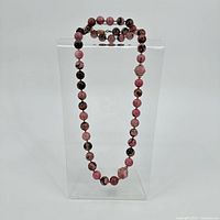 Full view of the rhodonite bead necklace hanging to show length and overall bead appearance