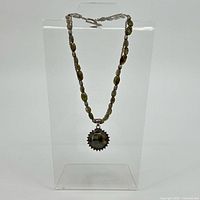 Full view of necklace hanging to show bead arrangement and pendant