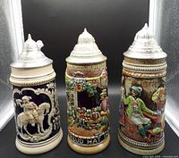 Three steins side by side showing overall designs and lids