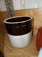 Front view showing tan body, brown band, blue crown "2" mark