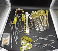 Entire lot laid out showing all strands, packs, bracelet and findings