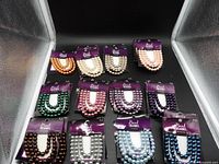 Multiple sealed packages of Bead Treasures 8mm glass pearl beads in various colours laid out