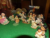 Group view of all ten Friends of the Feather figurines on green surface