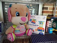 Plush puppy and boxed robot set on shelving