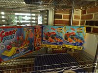 Wide shot showing all three boxed items on shelf