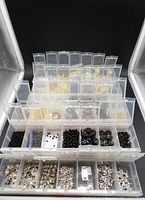 Front view of stacked clear locking bead containers showing variety of beads and findings