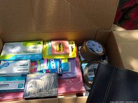Overview of box showing Post-it notes, envelopes, tape, paper clips, staples and note cards