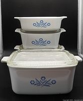 Front view showing three casseroles stacked on large one, Cornflower pattern visible