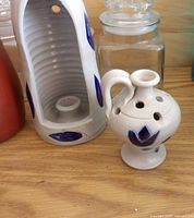 Lantern candle holder beside pierced jug showing color, motif and form