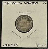 Reverse of 1878 Straits Settlements 10 cents coin in staple-mounted holder showing denomination and date