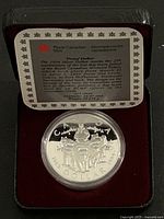 Coin in open clamshell case with certificate