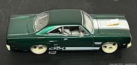 Left side view of metallic green 1970 Plymouth GTX diecast model