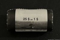 Full view of wrapped coin roll showing label '25 $ en 1 $' with loon image.