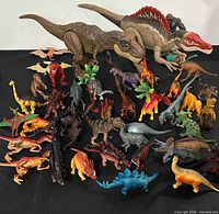 All 35 dinosaur figures grouped on black background