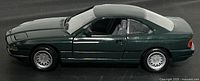 Left side view of dark green 1:18 BMW 850i model showing body condition and wheels