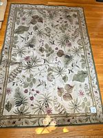 Full view of botanical area rug on wood floor