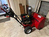 Full view of Craftsman red 24-inch snow blower showing handles, chute, tires, and overall condition