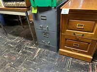 Gray metal filing cabinet beside oak wood cabinet, partial view of desk