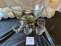 overall view of punch bowl on silver base with three sample cups and ladle