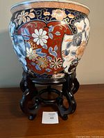 planter on wood stand front view showing floral and fish panels