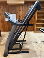 Side profile of folded ProForm treadmill with manual attached, shows overall form and condition