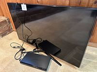 TV front view with Blu-ray player, cables and stand bar