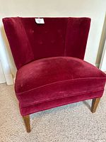Front view showing red velvet upholstery, button-tufted back, seat cushion, wooden legs