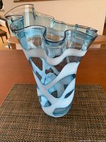 Front view showing blue blown glass vase with white swirl, ruffled rim