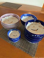 All three size stacks of cat face bowls on table