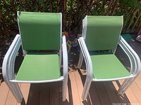 Pair of green sling chairs showing seat and back material with white frames