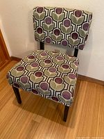 Front view of accent chair showing full shape, fabric pattern, wood legs