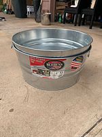 Close view of one Behrens steel utility tub showing label and side handle