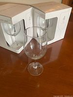 Boxed sets of four white wine glasses and one loose glass on table