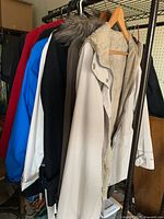 Rack showing multiple jackets: blue, black, light grey parka