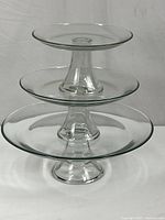three glass pedestal plates stacked tiered