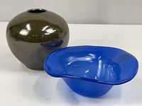Porcelain vase and blue glass dish side by side