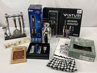 All items grouped: bar tool rack, Oster opener box, Vinturi aerator package, charms, shaker, flask set, towel, Wilton coaster box
