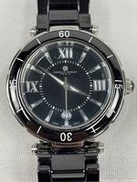 Front view showing black dial, bezel, Roman numerals, date window, and bracelet