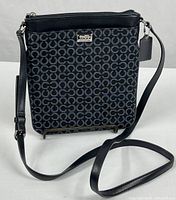 Front view of Coach Op Art crossbody showing strap, pattern, hardware, and ID tag