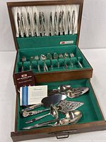 Chest open showing full flatware set and serving pieces