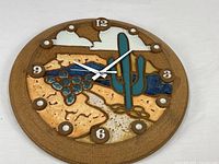 Full view of round pottery wall clock showing entire design and hour markers