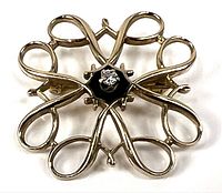 Front view showing floral loop design and central diamond