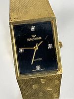 Front view showing black dial, crystal markers, Waltham branding