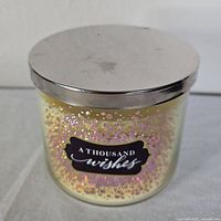 Front view of Bath & Body Works A Thousand Wishes candle with lid