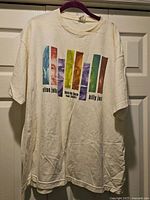 Front view of white tour T-shirt with full graphic