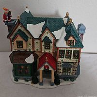 Front and side view of Lemax porcelain Christmas village house with Santa on chimney and snowy roof