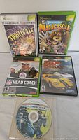 Front view showing five original Xbox games including four in cases and one loose disc
