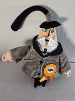 Front view of Mayor plush showing smiling face, jacket, ribbon